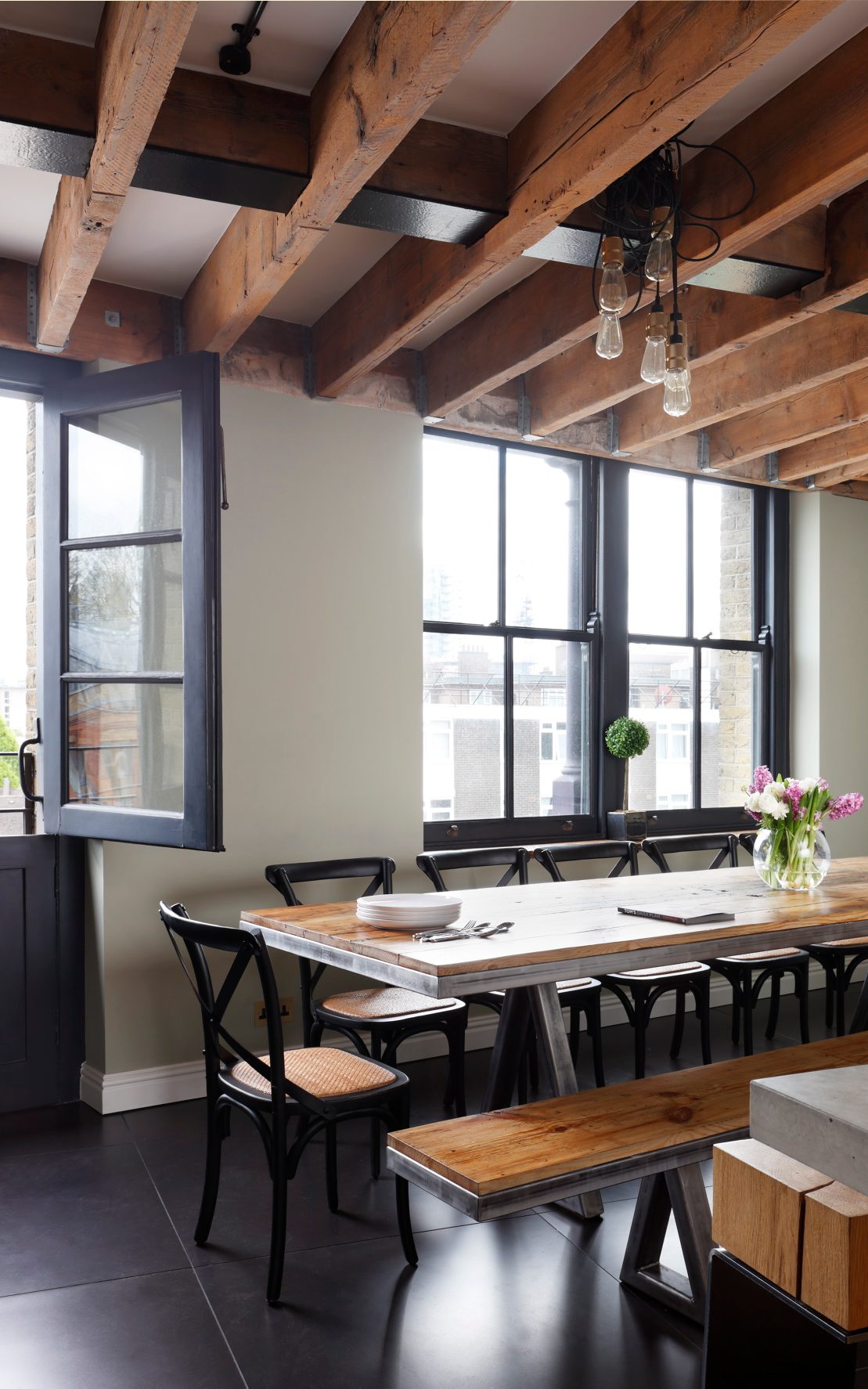 Partial view of THE LINE bar stool and dining table in Tom Daley’s open-plan loft kitchen with modern and industrial interior elements.