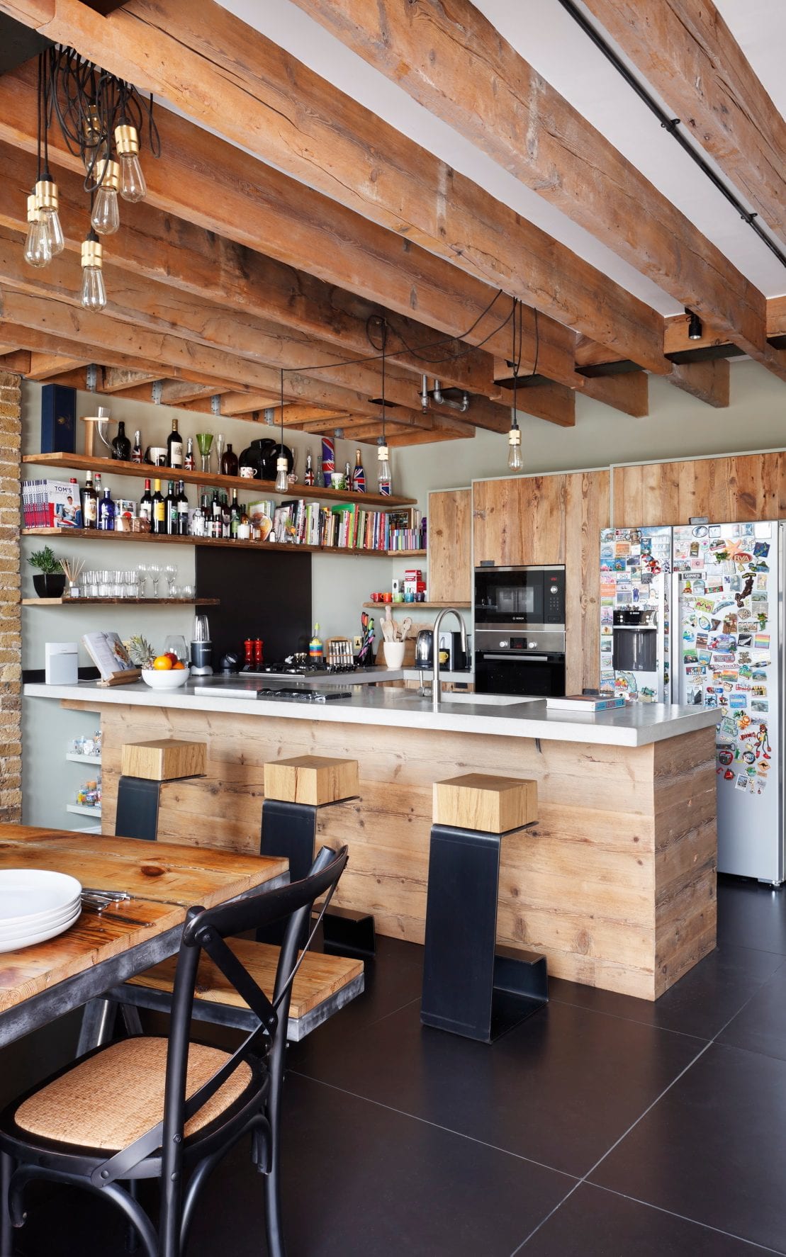 Full view of THE LINE bar stools at Tom Daley’s kitchen island in his modern industrial loft apartment in London.