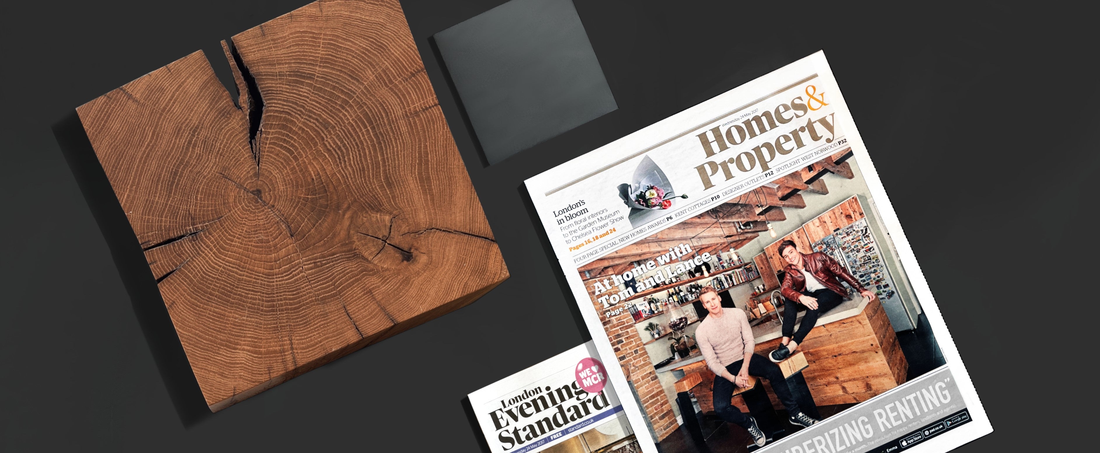 Tom Daley and Dustin Lance Black at home in their London loft kitchen, sitting on THE LINE bar stools made from oak and steel, showcasing modern industrial design.