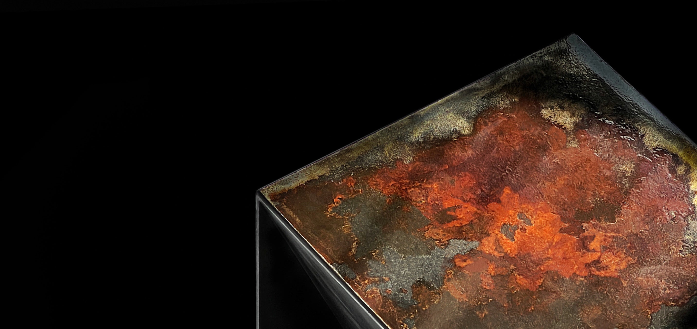 Close-up of rust-patinated steel top of THE BOX bar stool glowing in shadow, evoking a galactic or celestial landscape.