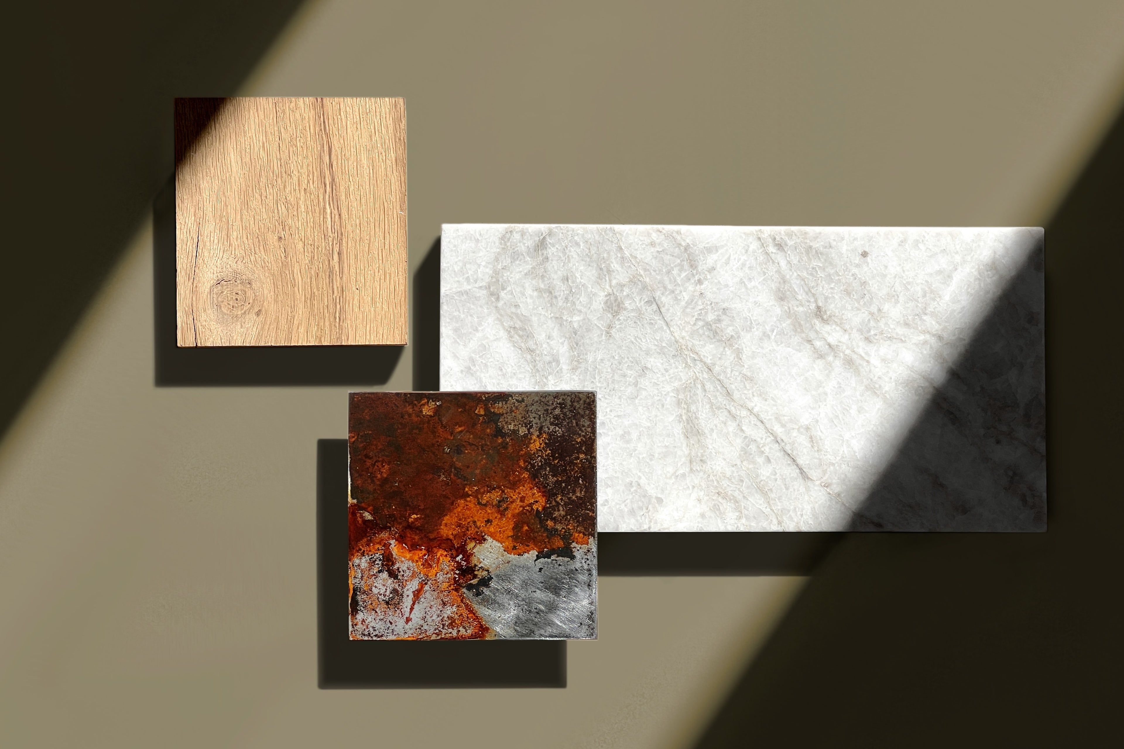 Inspiration board featuring a rusted steel sample next to oak and white marble, arranged in a geometric composition to illustrate a refined material palette for high-end interiors.